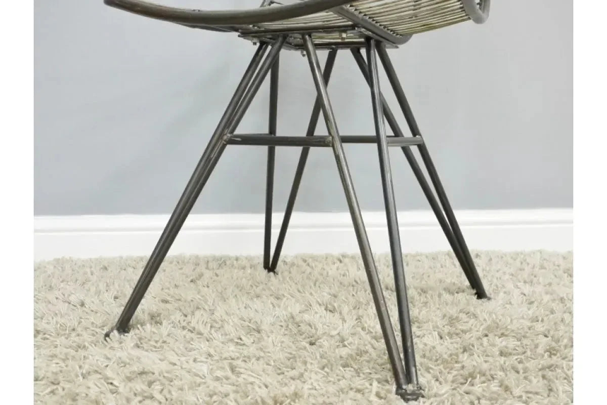 Metal chair legs and rattan frame closeup on light shaggy carpet