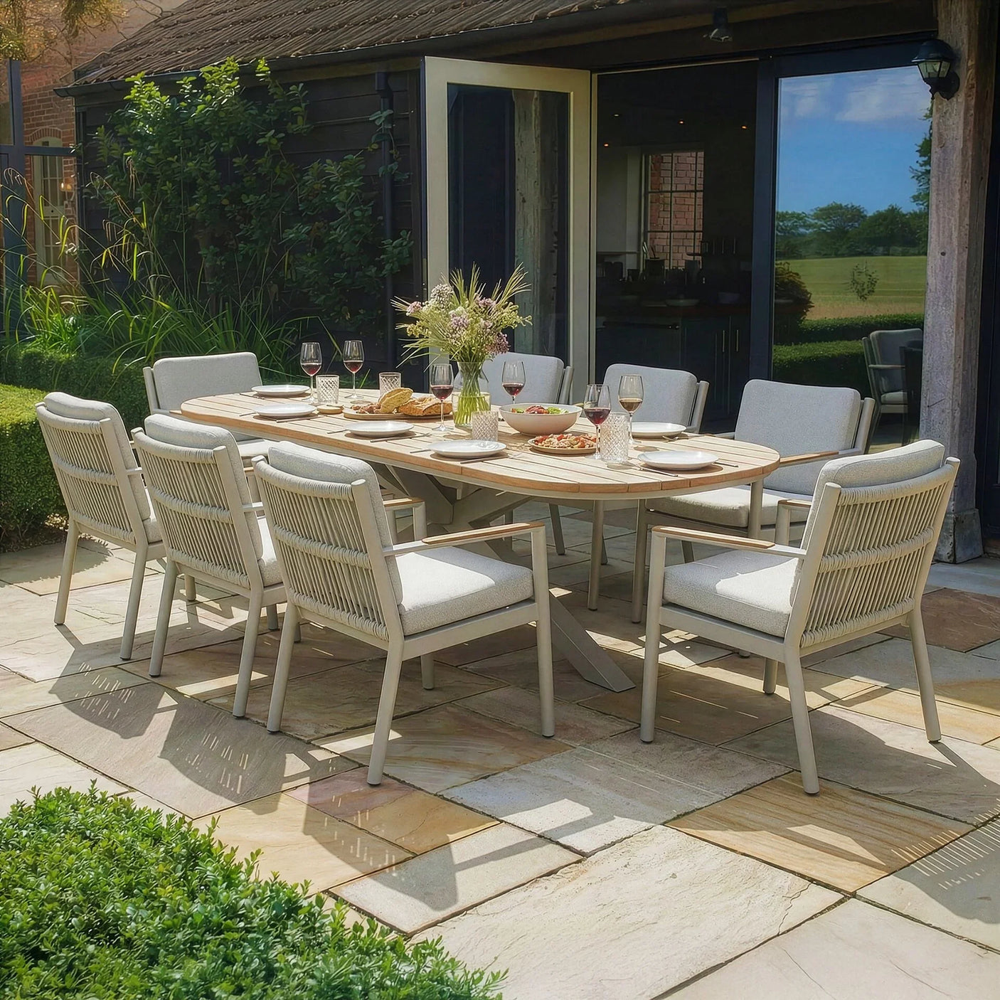 Outdoor garden dining set with eight cushioned chairs and rectangular wooden table on patio