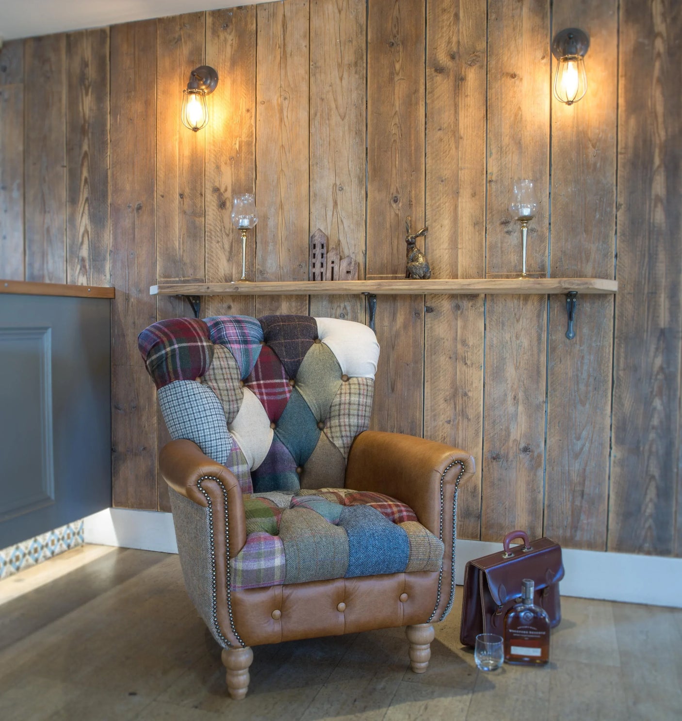 Patchwork armchair with leather arms in rustic living room setting