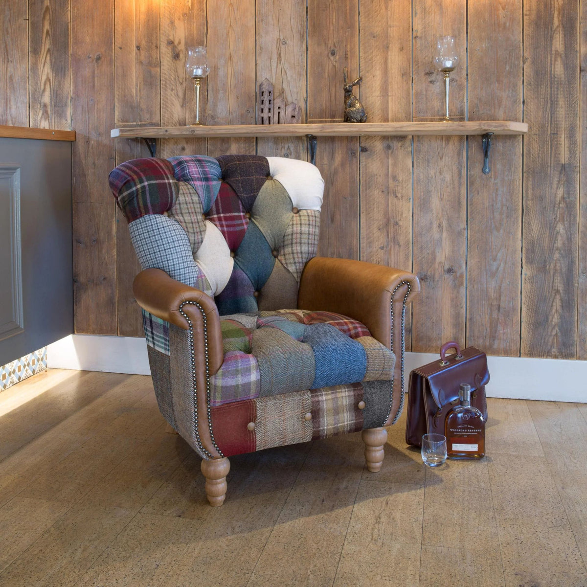 Patchwork tweed armchair with tan leather arms in a rustic room
