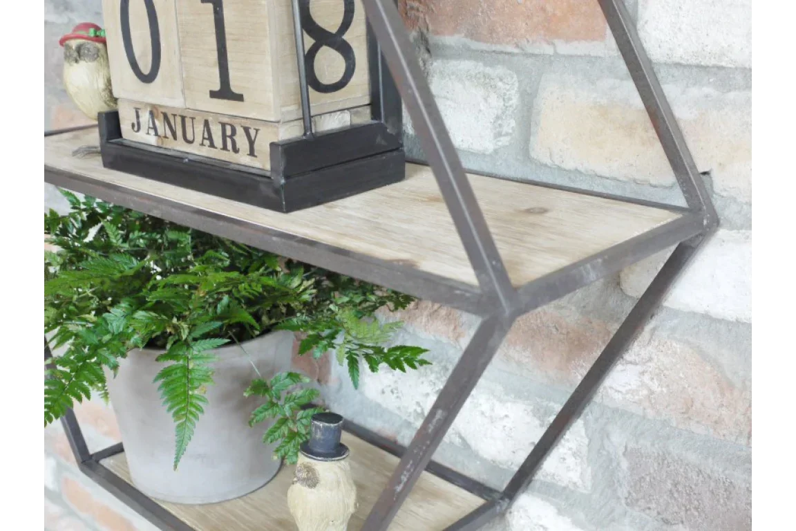 Geometric metal wall shelf holding wooden calendar and potted fern plant against brick wall