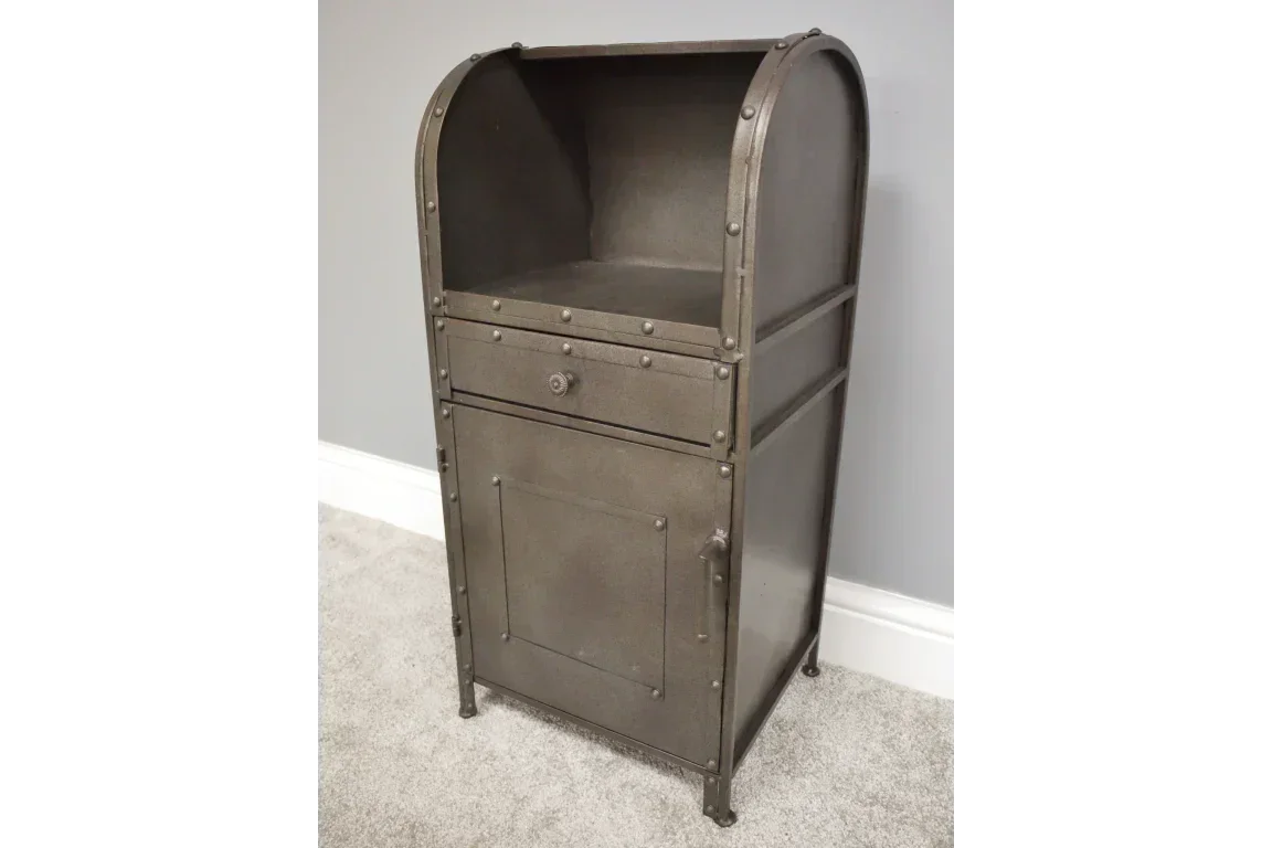 Industrial metal bedside cabinet with single drawer and lower cupboard on carpeted floor