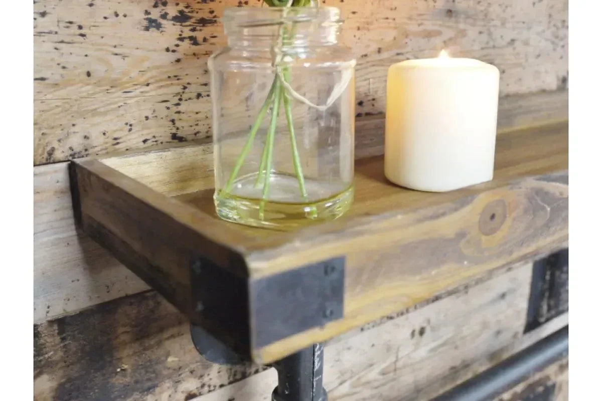 Industrial wood wall shelf with black metal brackets, holding a glass jar and candle