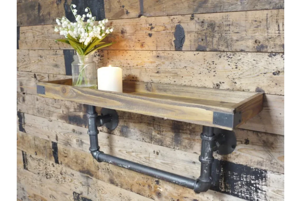 Industrial wooden wall shelf with black pipe brackets, candle and jar of flowers