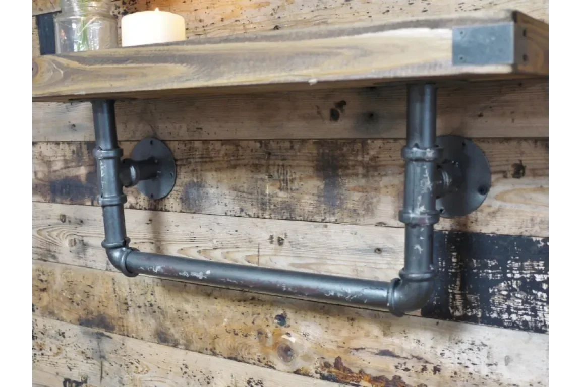 Industrial metal pipe shelf bracket with rustic wooden plank on reclaimed wood wall