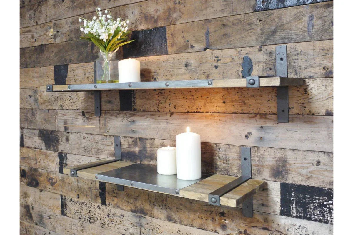 Industrial wood and metal wall shelves with white candles and glass vase on rustic timber wall