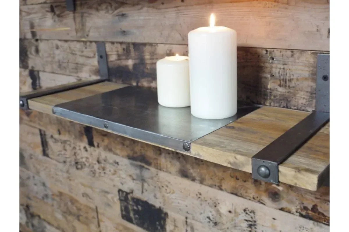 Industrial wall shelf with metal and wood detail holding two lit white pillar candles