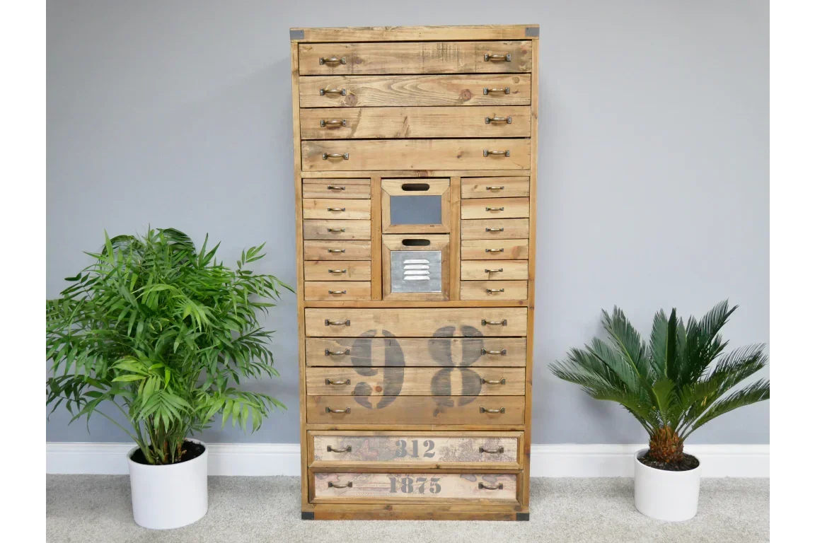 Industrial wood chest of drawers with metal accents and numbered fronts, between two plants