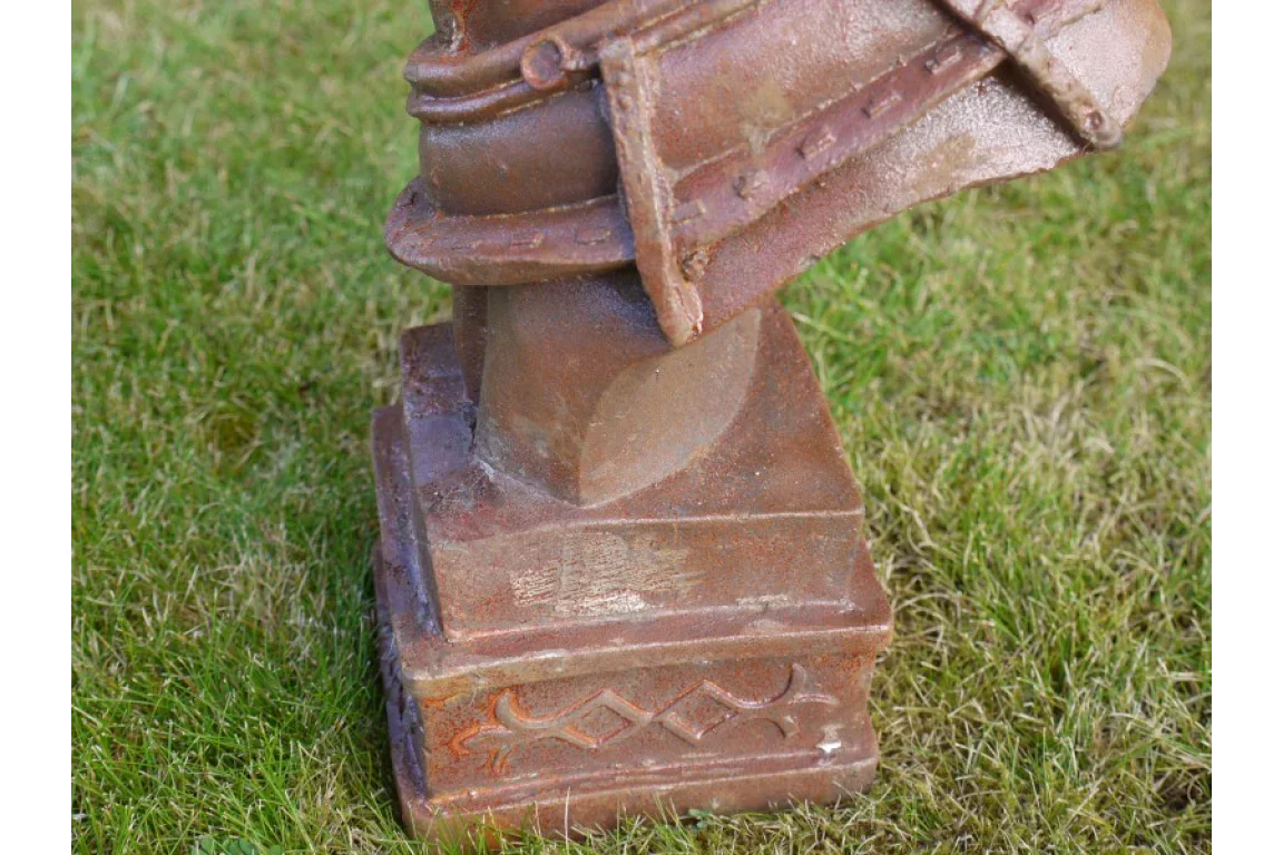 Cast iron garden ornament base with rust finish on grass