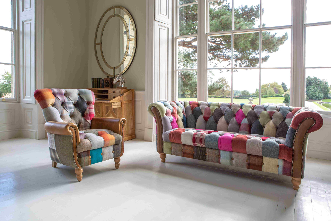 Patchwork fabric sofa and armchair with button tufting in bright living room with large windows