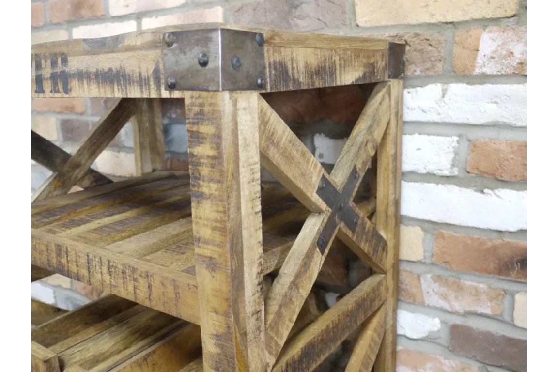 Rustic wood shelving unit with metal corner brackets and cross detail against brick wall