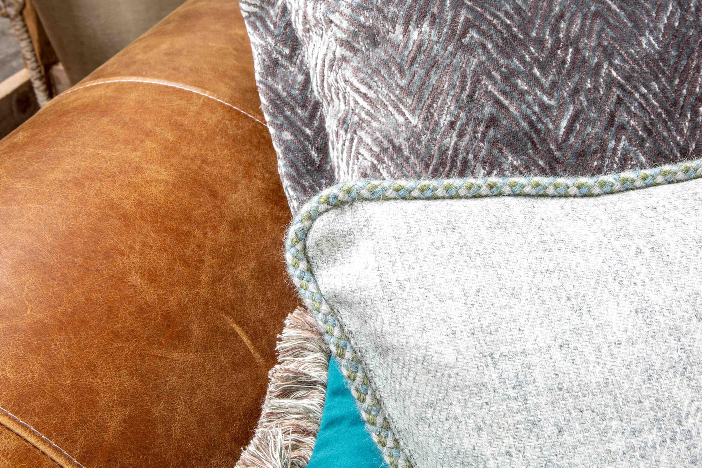 Brown leather sofa with textured grey and blue scatter cushions