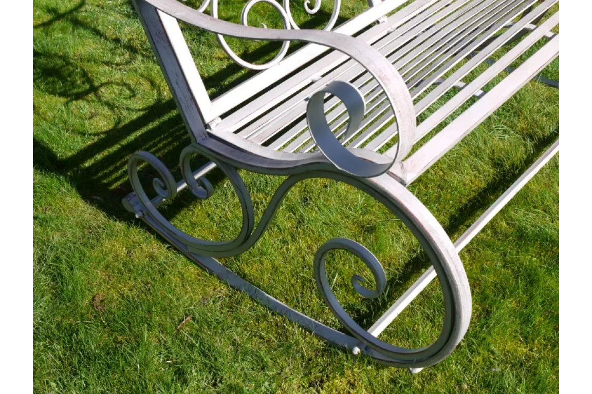 Metal garden rocking bench with decorative scroll armrest on grass
