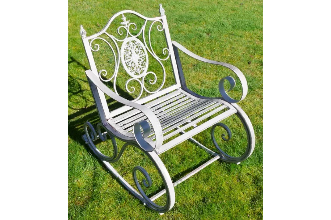 Decorative metal garden rocking chair with ornate scrollwork on grass lawn