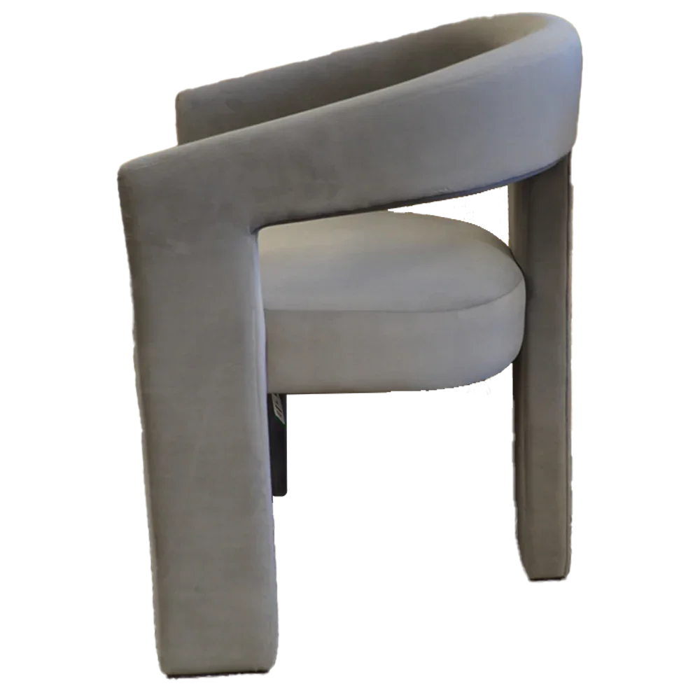 Grey velvet upholstered accent chair with curved backrest and modern design, side view