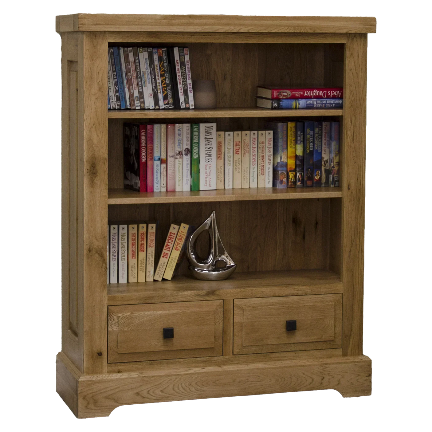 Oak bookcase with two drawers, books, DVDs, and a decorative ornament on lower shelf