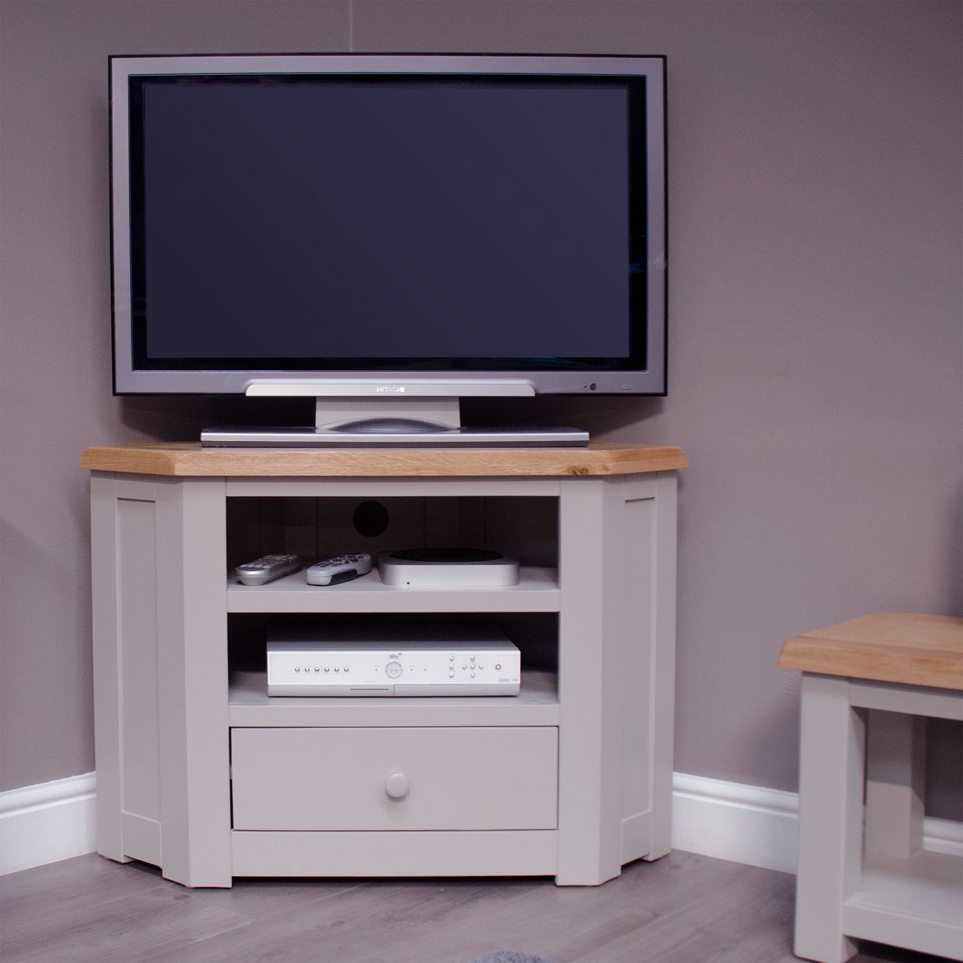 Corner TV unit with oak top, open shelves and drawer, painted light grey finish