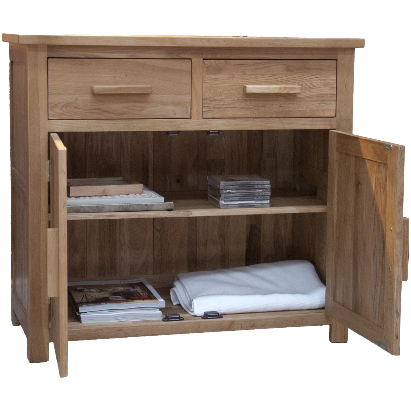 Oak sideboard with two drawers, open cabinet doors, shelves holding magazines and folded linen