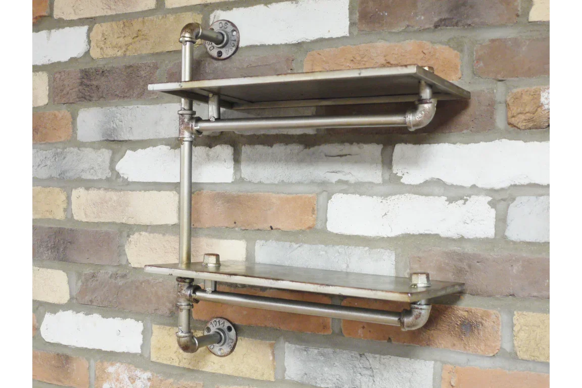 Industrial metal pipe wall shelf with two tiers mounted on exposed brick wall
