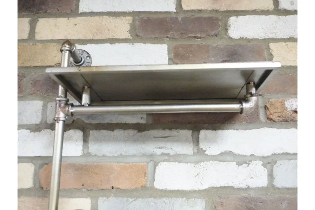 Industrial wall-mounted metal shelf with pipe fittings on exposed brick wall