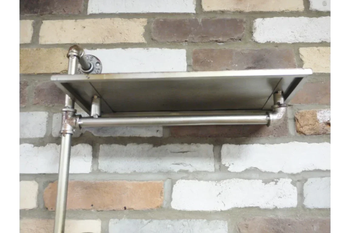 Industrial metal wall shelf with rail mounted on exposed brick wall