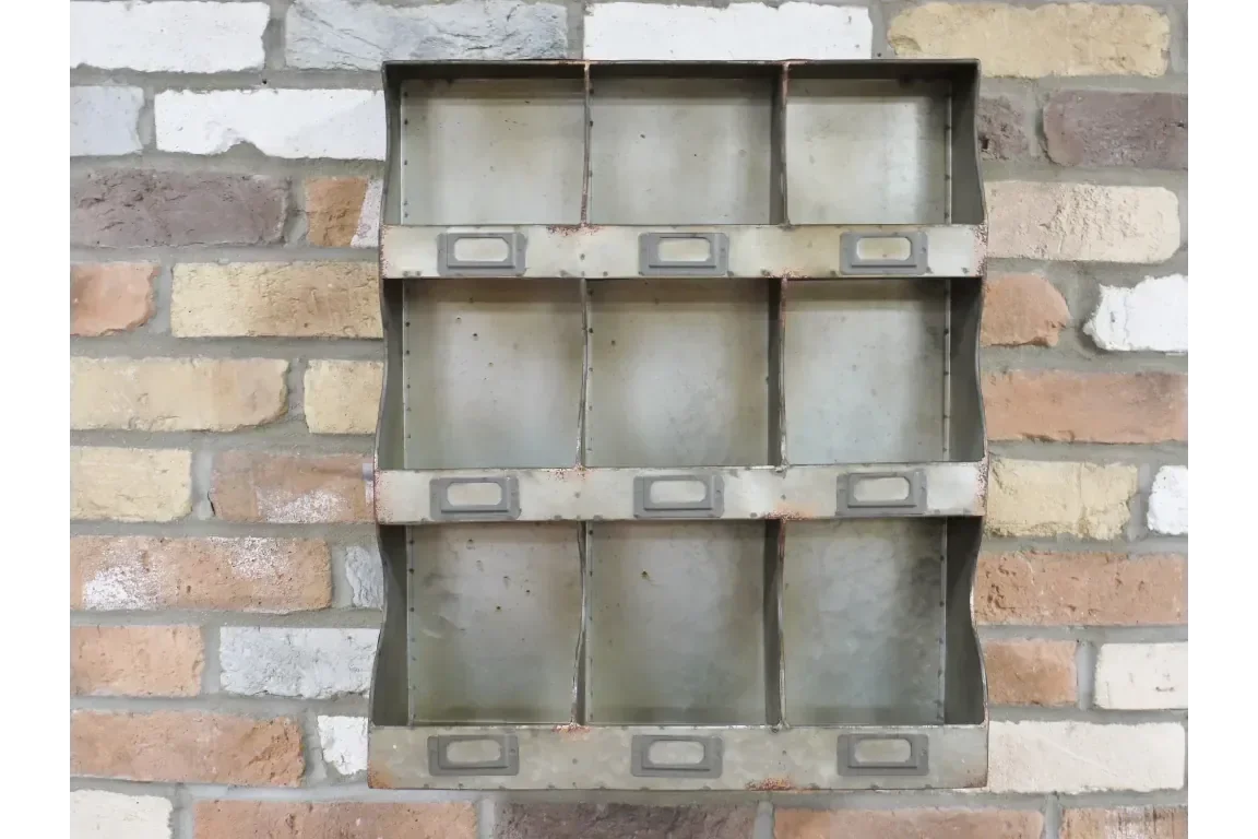 Industrial metal wall storage shelf with nine compartments mounted on exposed brick wall