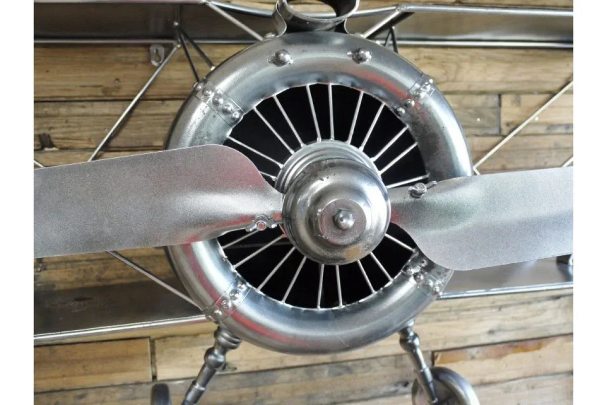 close-up of metal airplane propeller wall decor against wooden background