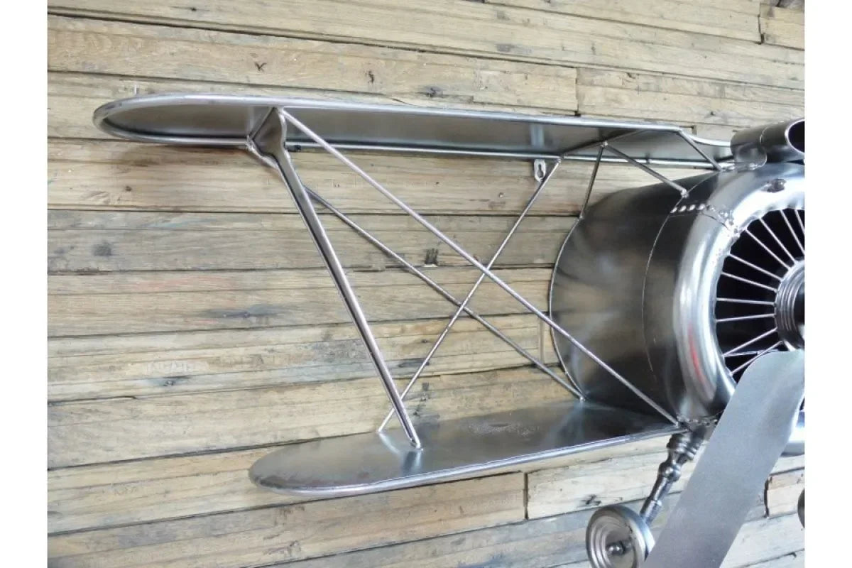 metal airplane wall shelf with propeller and double wings against wooden panel wall