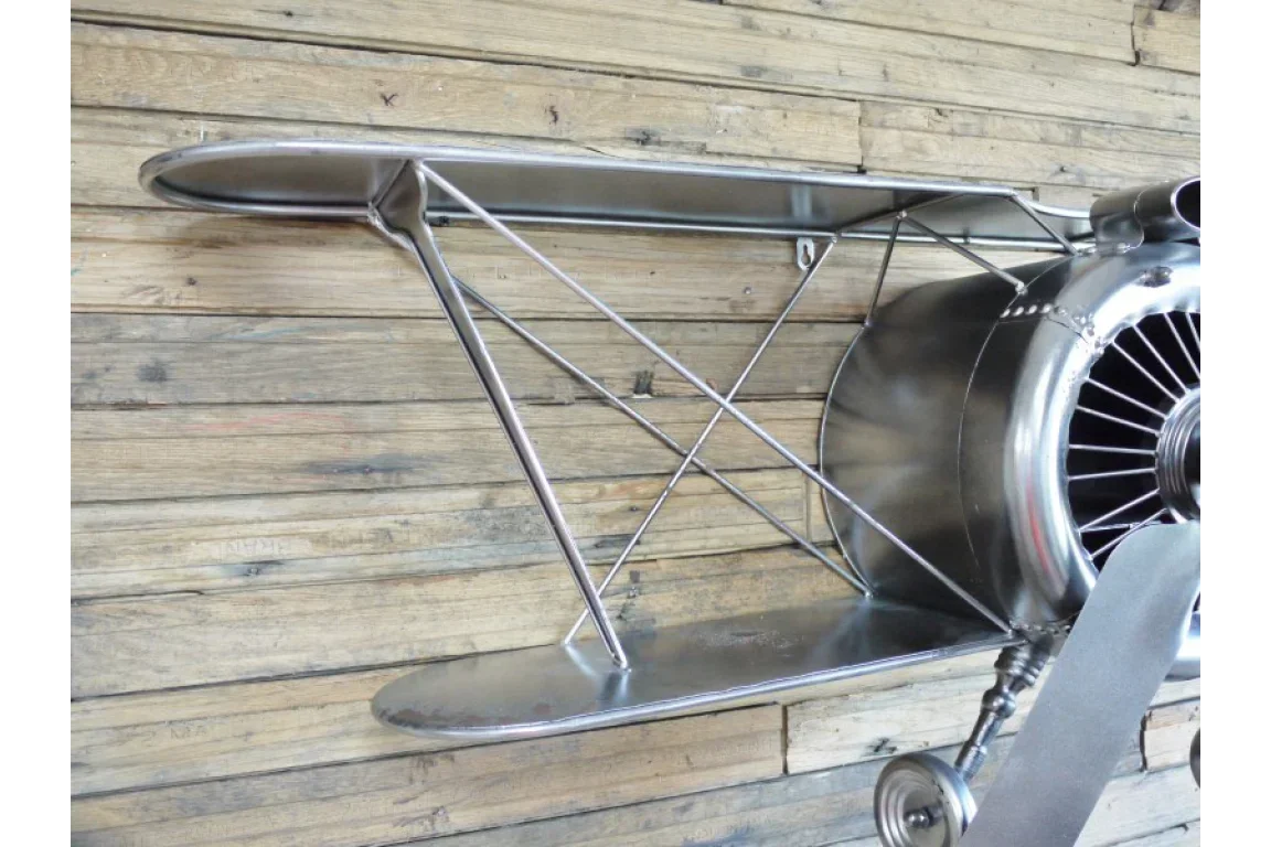Metal airplane wall shelf with propeller detail on wooden background