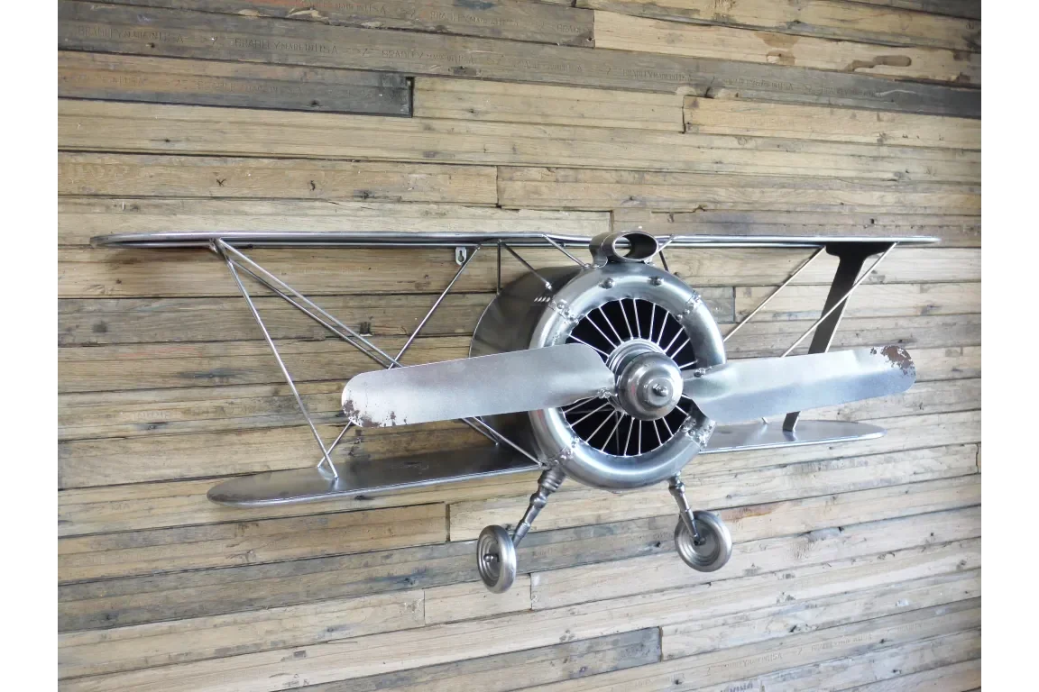 Metal airplane wall art with propeller on rustic wood panel wall