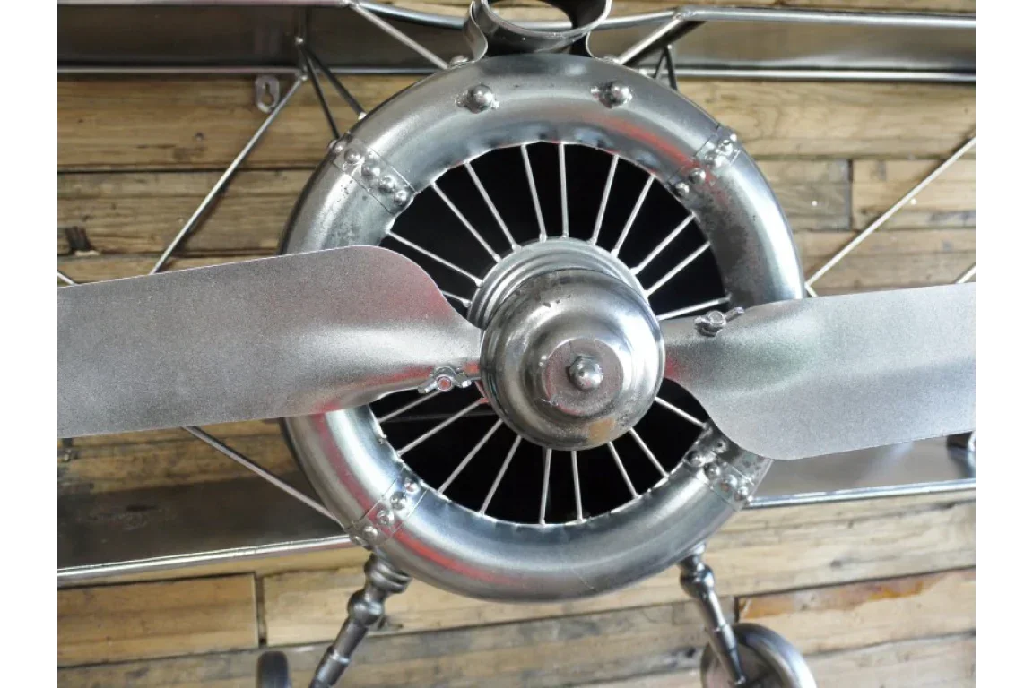 Close-up of silver metal airplane propeller wall decor on wooden panel