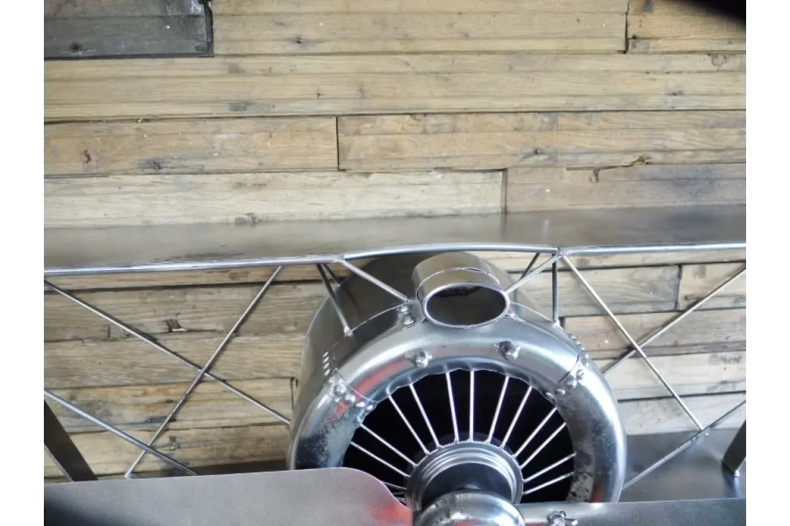 Silver airplane shelf with metal propeller and wooden backing, close-up front view