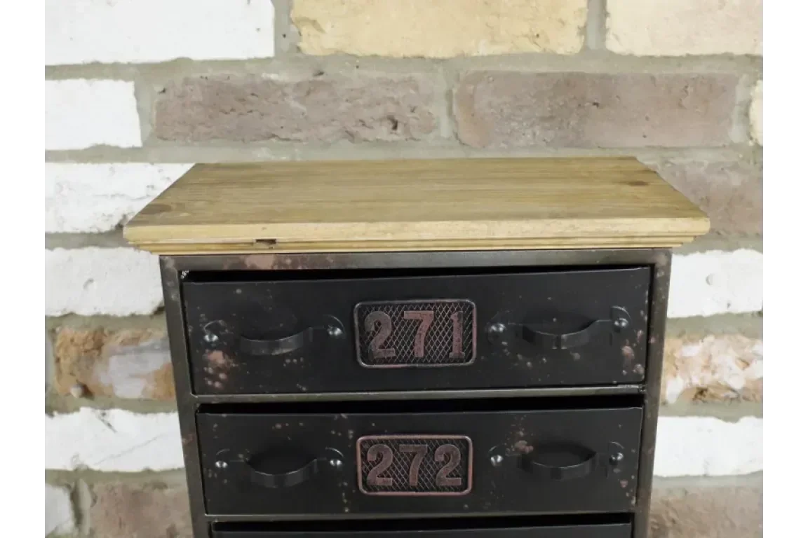 Industrial metal storage drawers with wood top and numbered fronts against brick wall