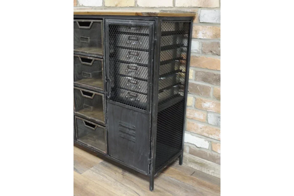 Industrial metal storage cabinet with mesh drawers and side door against brick wall