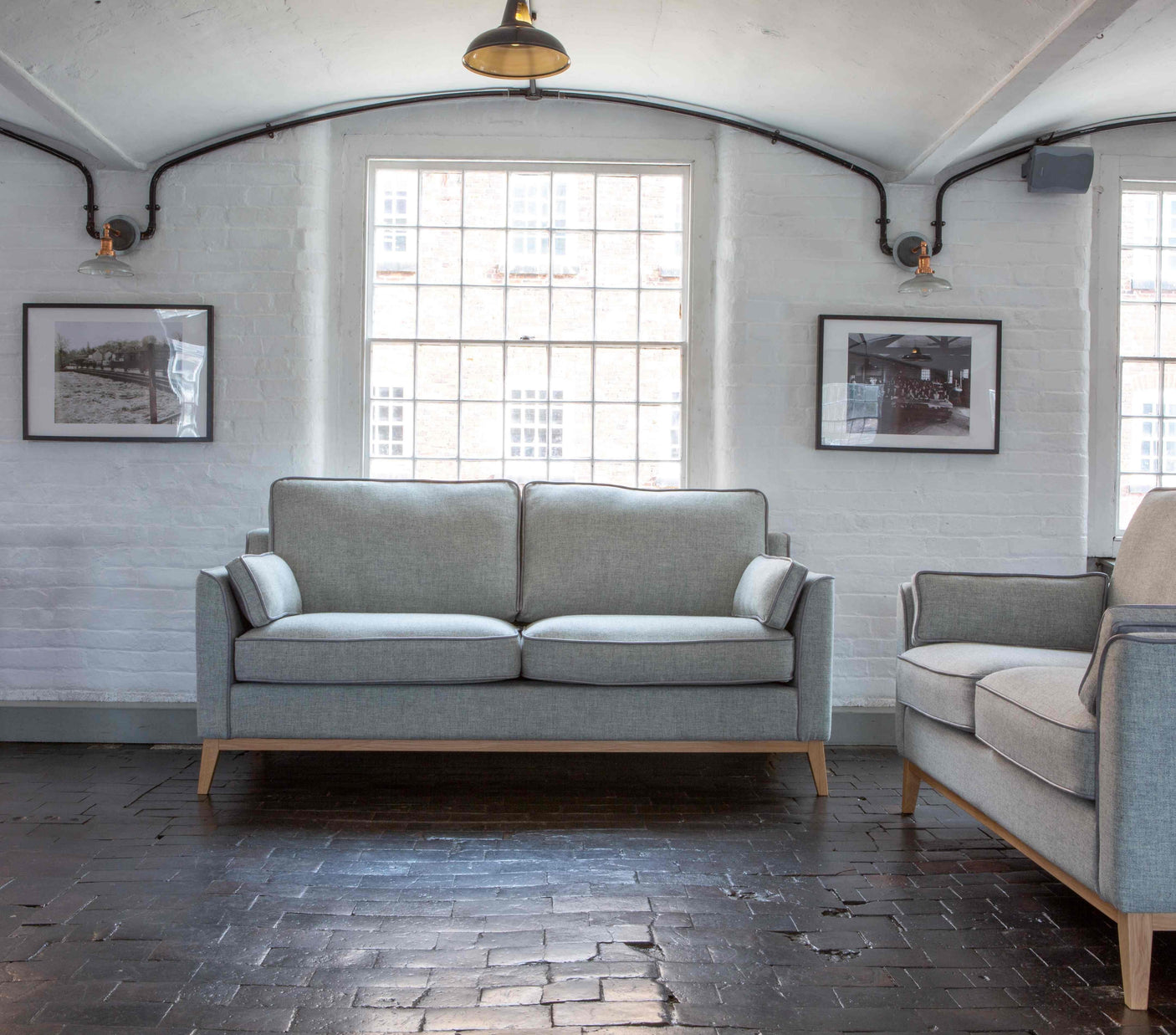 Light grey fabric sofa with wooden legs in a modern living room