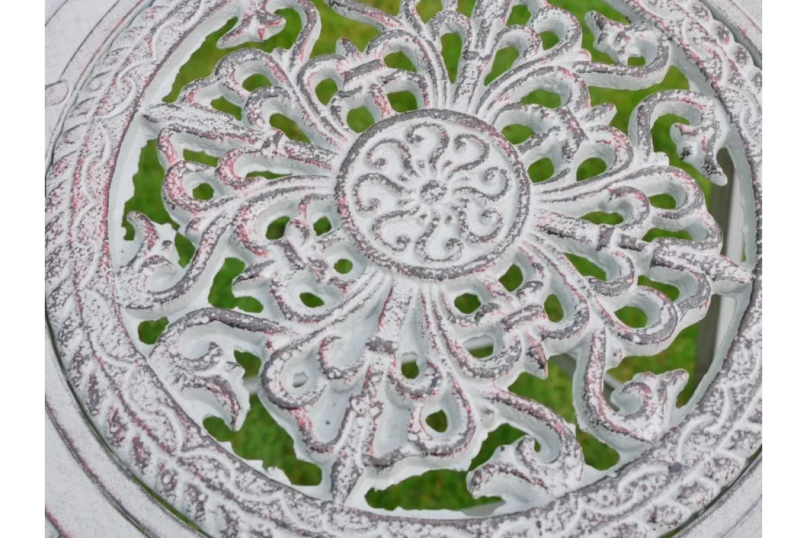 White cast iron garden table top with ornate floral pattern and weathered finish