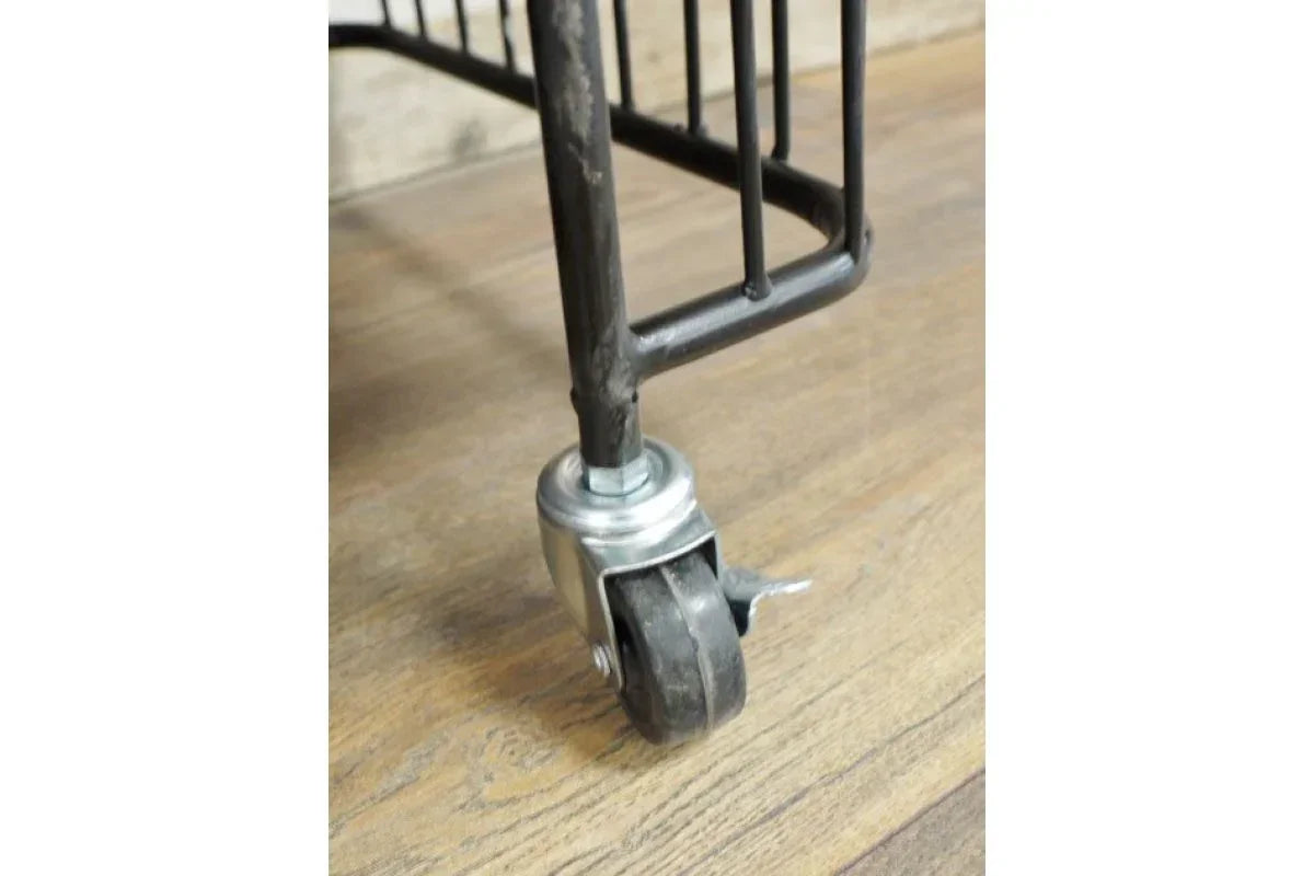 Metal furniture leg with black caster wheel and brake on wood floor