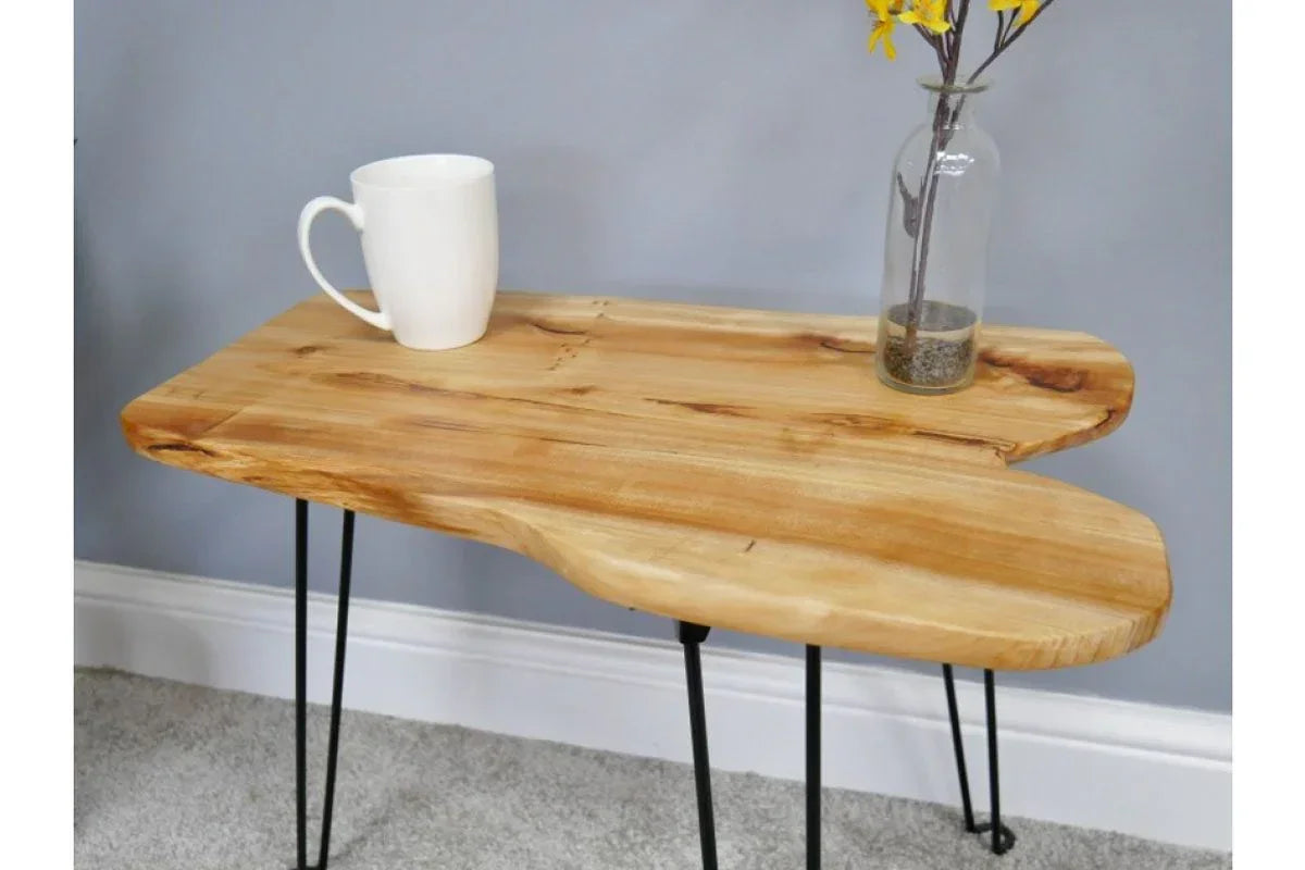 Live edge wooden side table with black metal legs, mug and glass vase with yellow flowers