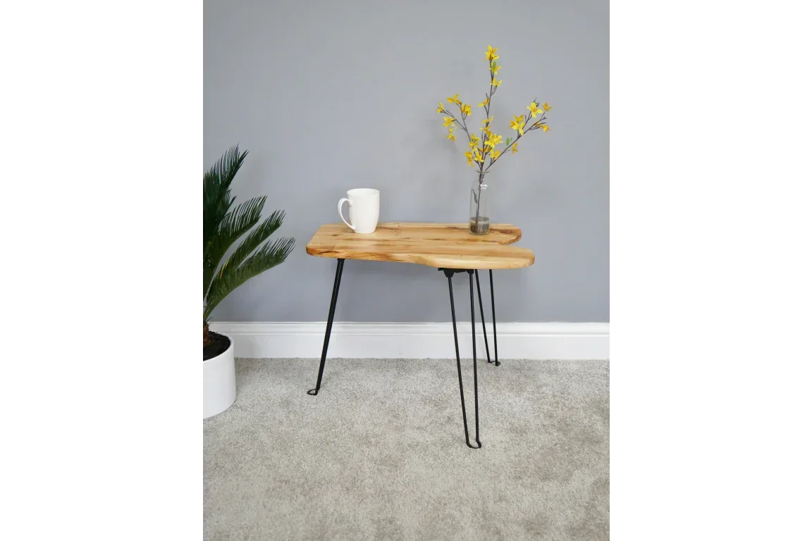 Wooden side table with black metal hairpin legs, mug and vase with yellow flowers on top