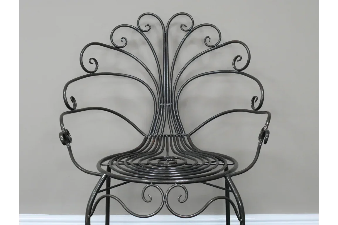 Black metal accent chair with decorative scrollwork and curved backrest