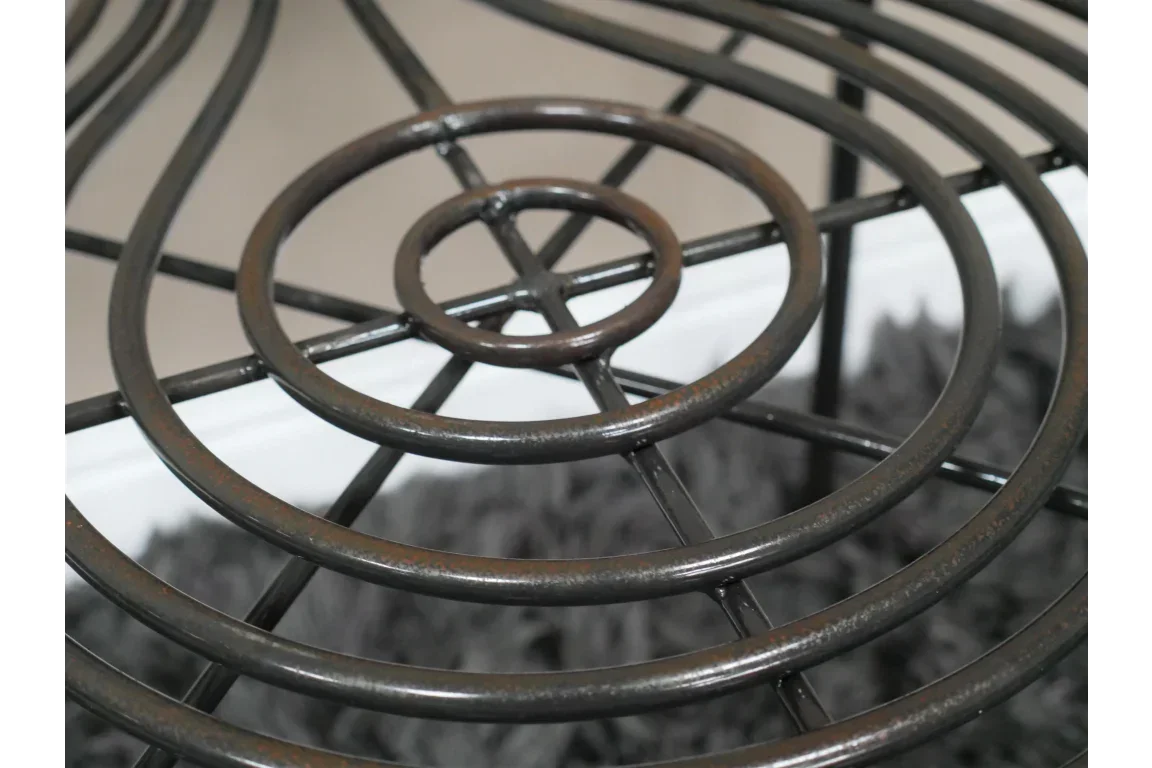 Black metal table top with circular wire design over grey rug