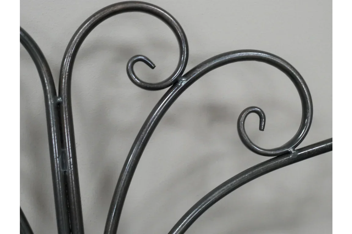 Close-up of black metal headboard with decorative scrollwork design