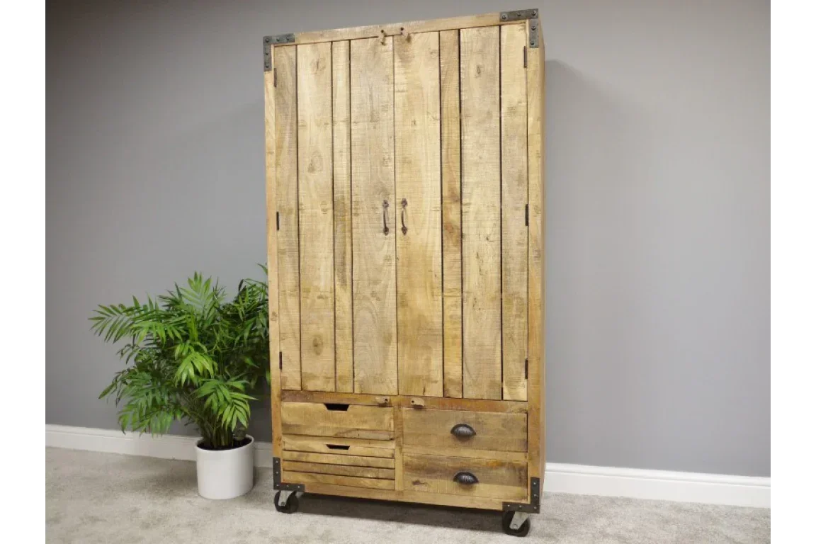 Rustic wooden wardrobe with drawers and metal handles on castor wheels beside potted plant