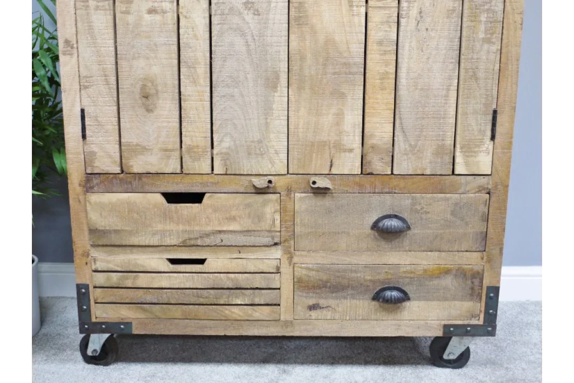 Rustic wooden cabinet with four drawers on metal wheels and black cup handles