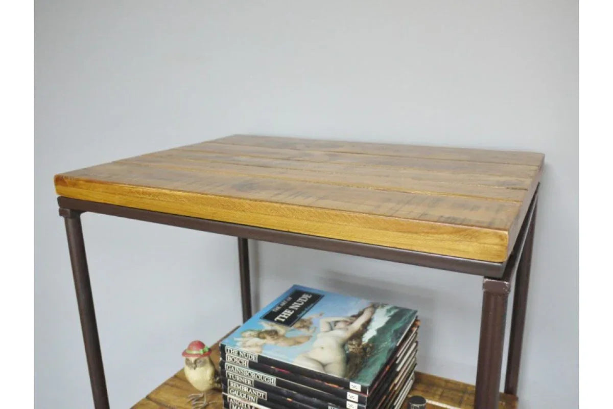 Industrial wood and metal side table with magazines on lower shelf against grey wall