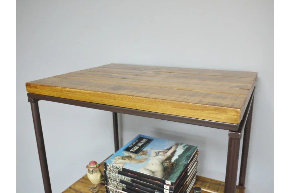Industrial side table with wooden top and metal frame, shelf holding books and small bird figurine