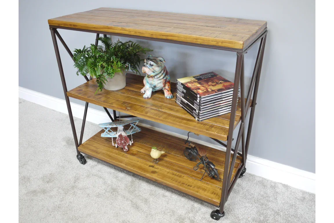 Industrial wood and metal console table with shelves styled with books, plant, and decor items