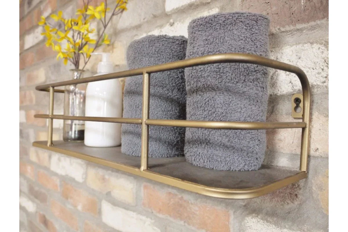 Metal wall shelf with grey towels, glass vase and soap dispenser against brick wall
