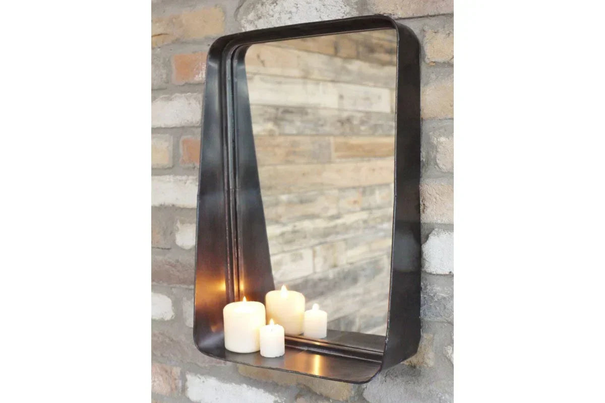 Rectangular metal wall mirror with shelf and candles against exposed brick background