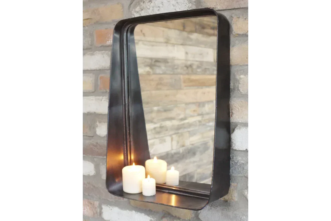 Rectangular wall mirror with metal frame and shelf, three pillar candles on shelf
